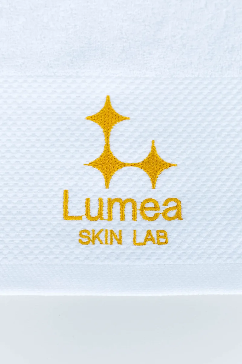 Toalha bordada com a marca Lumea Skin Lab